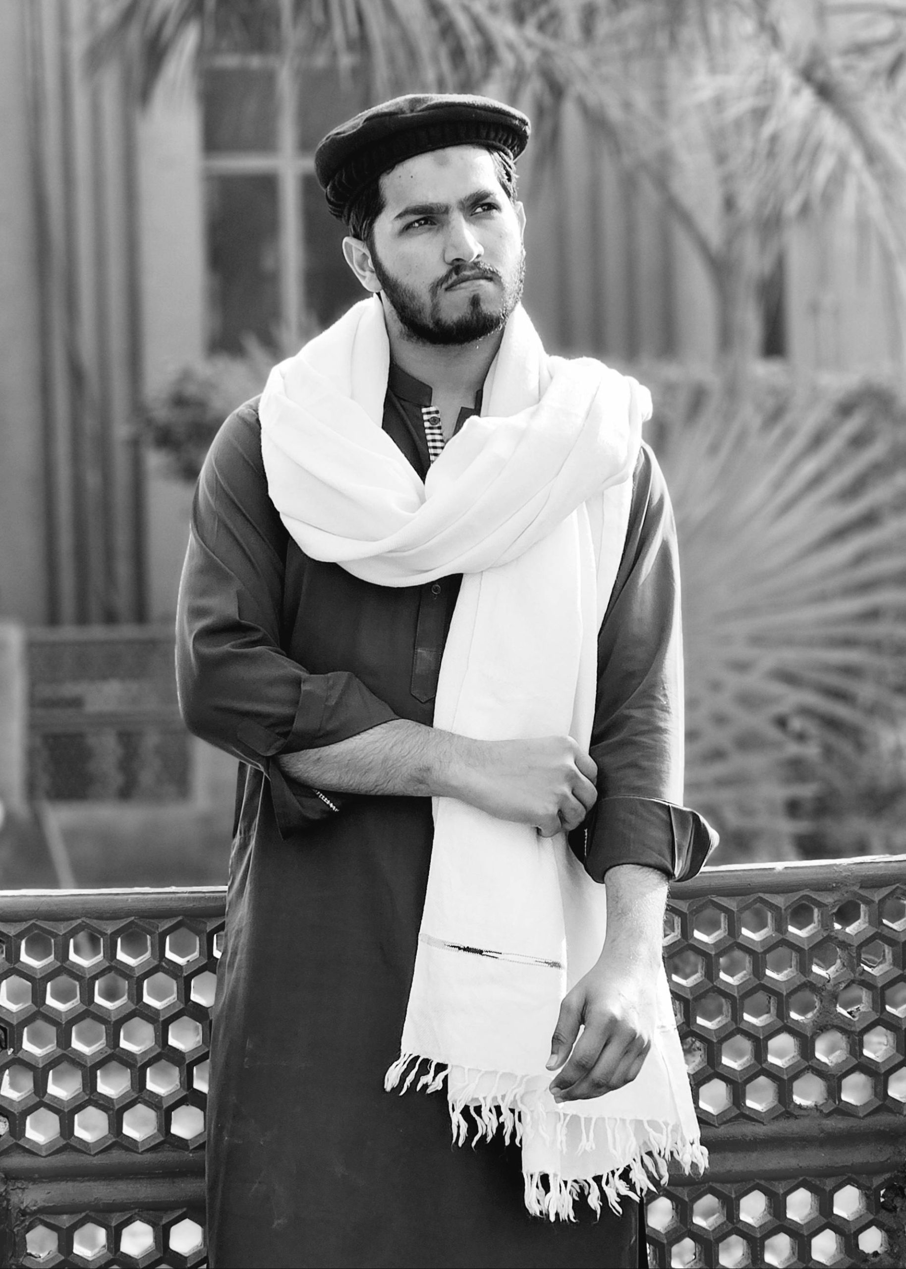 Portrait of a Pakistani man in traditional attire with a shawl outdoors.